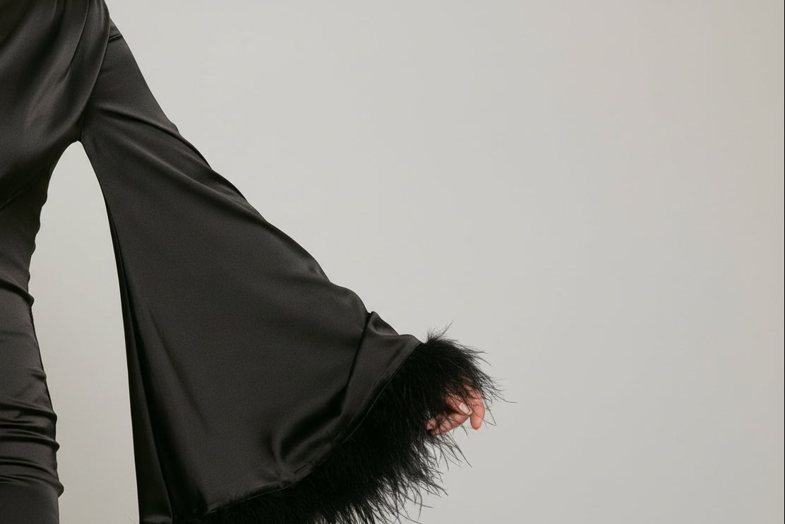 Black dress with feathered hem on a white background